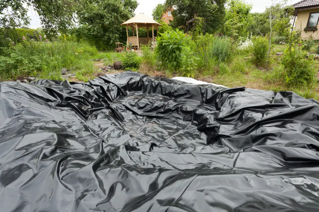 Black vinyl sheet cover hole on the ground to be used as a pond for fish